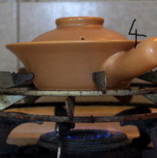 4、腊味煲仔饭,煲放火上,大火把米饭煮开,锅底一定要离火远远的, 不然会糊的很快,看到我的架子了吧,真不是盖的,帅呆了,就是有点脏哈,嘎嘎