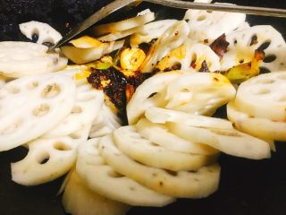 8、香辣什蔬干锅 超级开胃素菜,加入适量火锅料炒散后，倒入藕片，加入2勺料酒，一起中火翻炒约30秒。