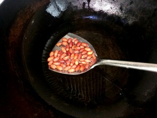 12、#猪年##猪五花# 蒜泥白肉,锅中放入适量植物油，放入花生翻炒至红衣爆开