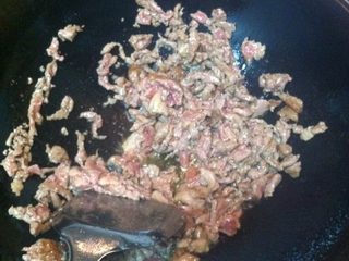 6、双椒爆孜然羊肉,将羊肉迅速倒入锅里撒上孜然粉，炒至变色