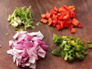 2、醋泡花生米,把青红辣椒洗净后去籽，用刀切成小丁，洋葱切小丁，香菜摘洗干净后切段。