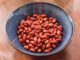 6、醋泡花生米,把炒好的花生米盛到碗里。