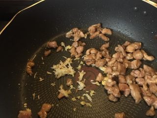 8、豆角猪肉炒鸡蛋,放入姜末和蒜末一起炒香。