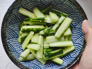 7、酸辣黄瓜条,双手捧着碗，上下颠十几二十下，让细盐和黄瓜充分混合
