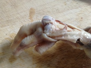 11、无骨鸡爪,在关节处左右摇向下掰，漏出骨头，用刀划去骨头两边肉，底部切一刀，保留脆骨。