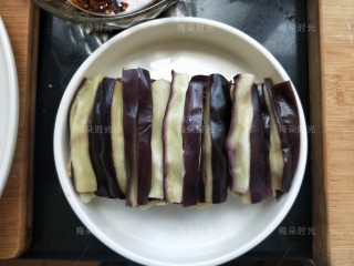 3、蒜香蒸茄子,蒸熟后打开盖子自然冷却。等放凉后整齐的码入盘中。