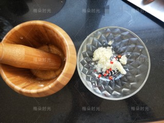 4、蒜香蒸茄子,开始做凉拌汁。先用蒜臼子捣点蒜泥，再切一个小米辣。