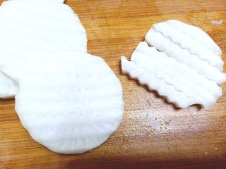 2、柠檬泡椒萝卜条,用波纹刀切片，在改刀切条