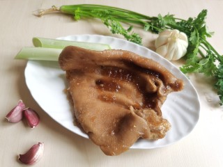 1、凉拌猪耳朵,准备煮熟的猪耳朵一个，大葱和香菜各一棵，还要几瓣大蒜。