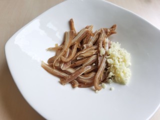 6、凉拌猪耳朵,将猪耳朵放入盘中，加入蒜末。