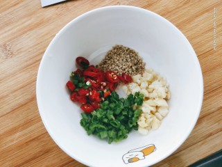 3、皮蛋豆腐,蒜切末，葱切花，小米椒切圈，适量白芝麻。放在碗里备用