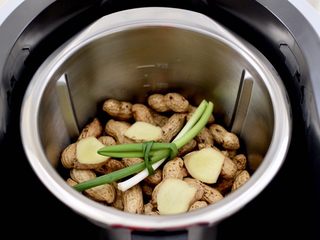 5、盐水花生,主锅再次放入洗净后的花生，放入姜片和打结的小葱。