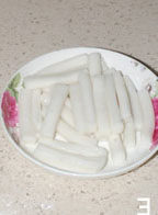 1、干锅基围虾,年糕掰开，入锅煮软后沥干水份备用；