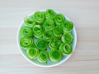 12、凉拌黄瓜卷,把卷好的黄瓜卷放到盘子里。