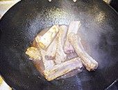 8、无锡排骨,锅继续烧热，将姜放入炒香之后加入排骨、黄酒、老抽、葱炒匀