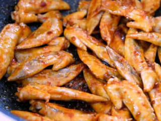 5、世界杯看球嘴馋的最好伴侣——下酒鸡尖,倒入料酒,迅速炒香 ,再加入辣椒酱,炒匀