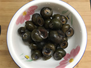 2、剁椒田螺酿肉,剪去尾部后再用刷子把外壳刷彻底干净。