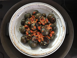 12、剁椒田螺酿肉,上面放上剁椒，多少看各人的口味哈，再放少许生抽后放入蒸锅，水开后大火蒸10分钟左右即可出锅。