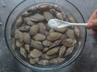 2、爆炒花甲螺,花甲用水浸泡着，放入一小匙盐，让它吐干净泥沙；