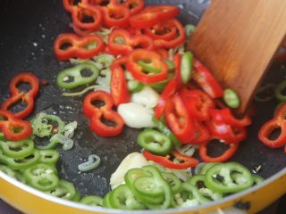 8、爆炒花甲螺,大葱炒出香味后倒入辣椒圈翻炒;