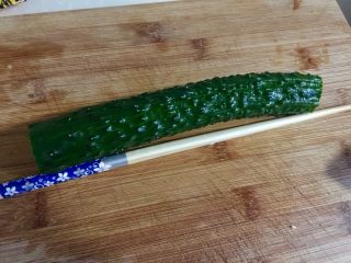 7、下酒凉菜的绝对主角➕麻辣入味簑衣黄瓜,准备切簑衣喽。黄瓜切掉两头，取一根筷子贴着黄瓜边摆好