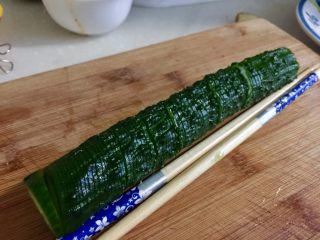 8、下酒凉菜的绝对主角➕麻辣入味簑衣黄瓜,手按着黄瓜和筷子（我是黄瓜两边各摆了一根筷子）刀斜着45度角切黄瓜片（/这样切）每刀切到筷子不切断，黄瓜片尽量切的薄而均匀，这是个细致活，不过并不难，大家慢慢来就可以，小心不要切到手