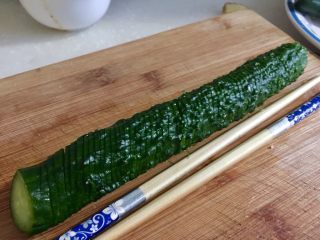 9、下酒凉菜的绝对主角➕麻辣入味簑衣黄瓜,把黄瓜翻转180度，同样按着筷子黄瓜，同样的角度（还是这样/切）切黄瓜薄片，厚薄均匀，不要切断