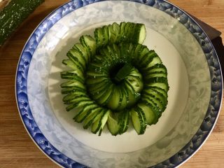 11、下酒凉菜的绝对主角➕麻辣入味簑衣黄瓜,将切好的簑衣黄瓜摆盘，摆盘时可以把黄瓜拉开一点。感觉有点像小时候玩的拉拉圈（不知道这个词会不会被屏蔽啊，嘿嘿）