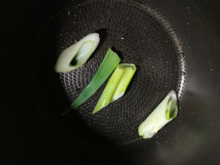 4、五香酱牛肉,取出压力锅内胆 锅底铺上葱段