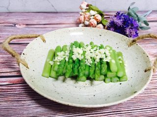 9、蒜蓉芦笋,沥干水分的芦笋摆入盘中放入蒜末