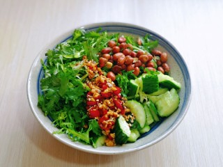 10、蒜泥黄瓜,将调味汁淋在黄瓜苦菊上,放入熟花生米,拌均匀即可。