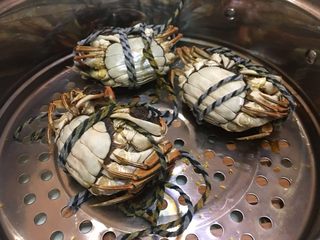 5、清蒸阳澄湖大闸蟹,蒸锅大火烧开水后，将大闸蟹肚子朝上摆放，防止蟹膏蒸熟后遗漏出来，设置好闹钟大火蒸15分钟即可取出食用。