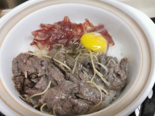 8、广式煲仔饭,时候到了，闻到饭焦香和肉香，开盖打只鸡蛋在表面，马上盖上煲盖，关火！！！继续焖焗10分钟左右。