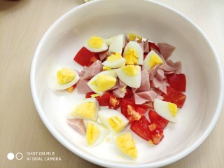 9、藜麦生菜沙拉,将切好的鸡蛋、番茄、火腿放到一起。