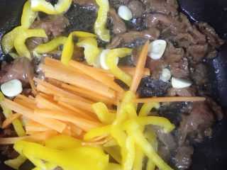 12、广式干炒牛河,放入蒜片、彩椒、胡萝卜