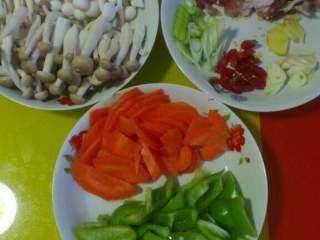 2、双菇炒肉,把蟹味菇和白玉菇的跟切掉，柿子椒 胡萝卜 五花肉 葱 姜 蒜切片儿，干红辣椒切段儿，如图备好！