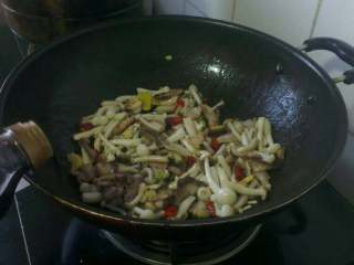 6、双菇炒肉,再倒入焯烫好的双菇加生抽翻炒上色；