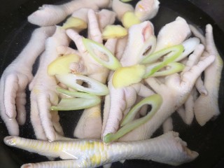 5、香辣卤鸡爪,处理好的鸡爪凉水入锅,放入大葱和生姜,加入一勺料酒。