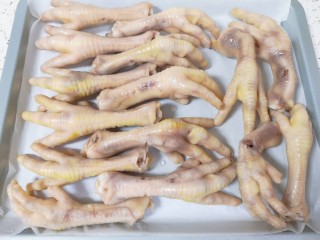 7、香辣卤鸡爪,准备一个盘子铺上油纸,将焯过水的鸡爪摆在油纸上,自然风干到鸡爪表面变硬(我一般是风干一个晚上,第二天早上起来卤),这样卤出来的鸡爪啃起来有嚼劲更好吃。