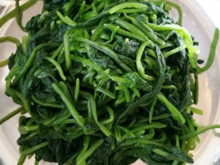 3、爽囗凉菜菠菜花生米,再捞出攥干水份，放盆里。