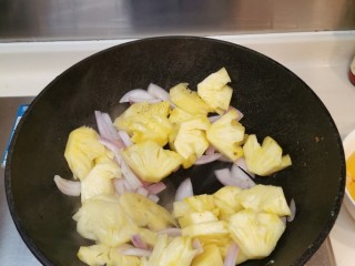 10、广式酸甜排骨,倒起锅内的油，放入洋葱、菠萝大火翻炒至熟，装上碟备用。