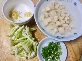 2、#年味儿#开胃爽口菜拌花藕,藕去皮切丁泡水里，花菜划小朵，韭菜切细，老姜蒜剁泥