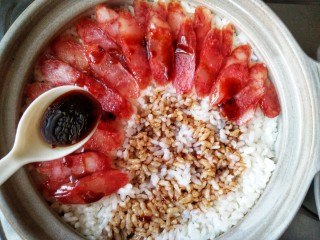 12、腊味煲仔饭,在腊肠上趁热淋上料汁，向米饭中间淋上两圈，再盖上盖焖2分钟分钟。在这两分钟里，料汁可以慢慢流到饭里，也可以让饭回一回气。（也有人认为，淋完豉油以后，就应该马上搅拌整煲饭，起饭焦，否则饭焦容易受潮，就不好吃了，这个看个人喜好吧）