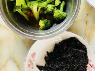 11、紫菜西兰花树（凉拌菜）,紫菜还没有拌调料。我们先把西兰花和胡萝卜装到另一盘，余下的汤汁用来拌紫菜。这样做不至于菜品有过多的盐量和油量。