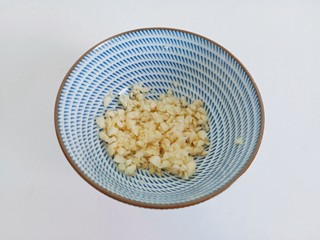 6、黄瓜拌腐竹,蒜放在案板拍一下，剥皮再剁成泥。