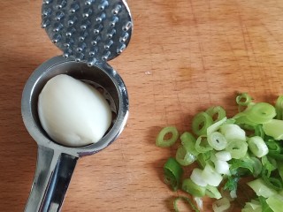 4、手撕鸡胸肉,取一个绝大一点的蒜,去尾,放入压蒜器中(网上厨房兑换的很好用)