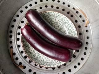 2、蒜泥蒸茄子,将长茄子洗净去头，放进盘中，开水上锅隔水蒸15分钟。