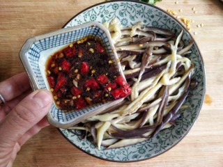 9、蒜泥蒸茄子,在撕好的茄子丝上浇上调好的凉拌汁。