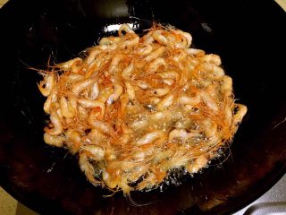 2、油爆小河虾,炒锅倒入多一些的植物油，大火烧至冒烟，下入小河虾，用铲子翻动，炸约20秒左右。