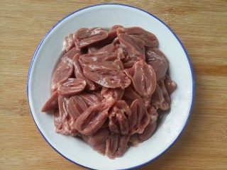 2、下饭又下酒的辣椒酱爆鸡心,用剪刀把鸡心表面的白色脂肪去掉，再用刀刨成两半后冲洗干净，沥干。